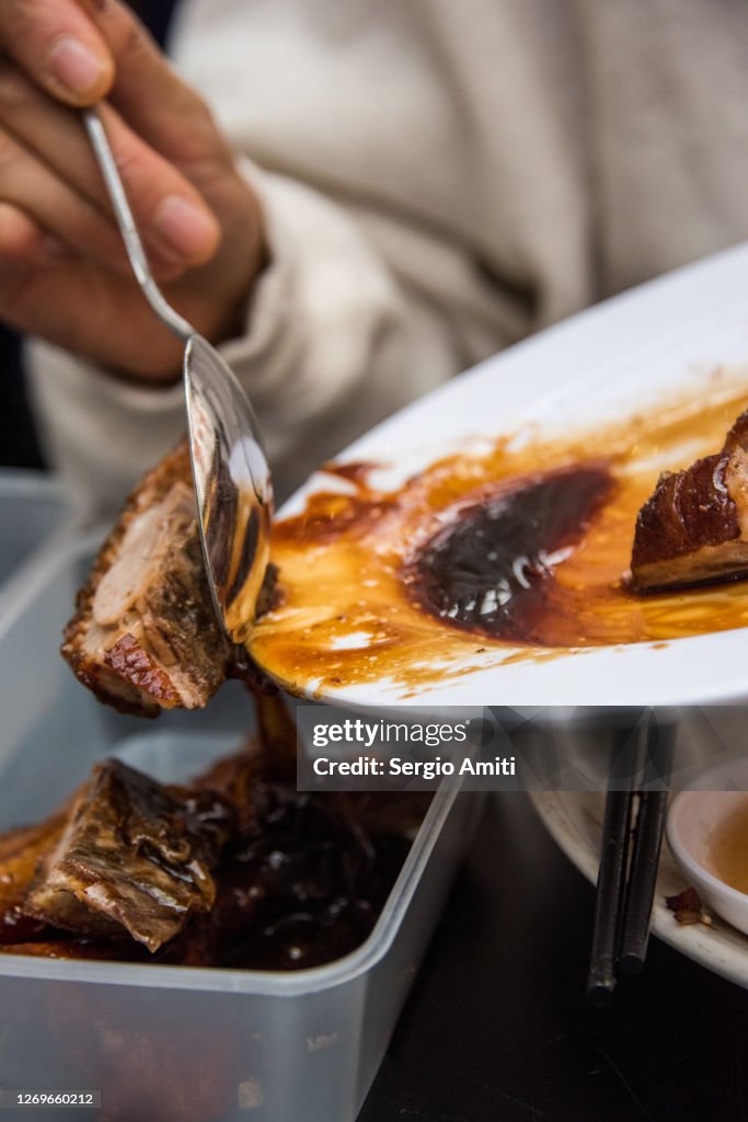 Chinese roast duck into a takeout container