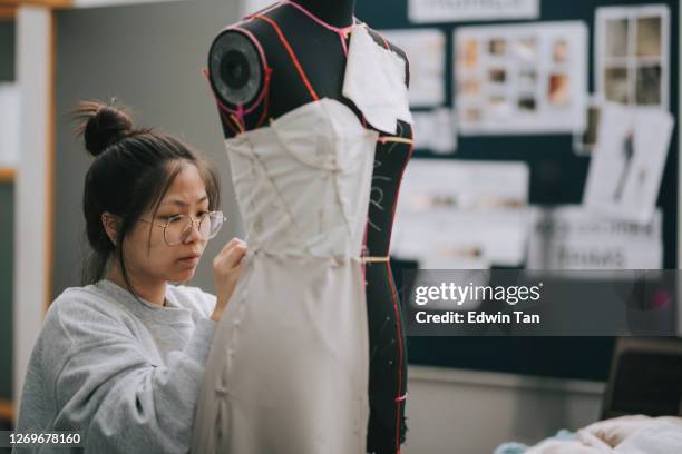 asian chinese female fashion college student doing clothing project at college workshop - fashion designer stock pictures, royalty-free photos & images