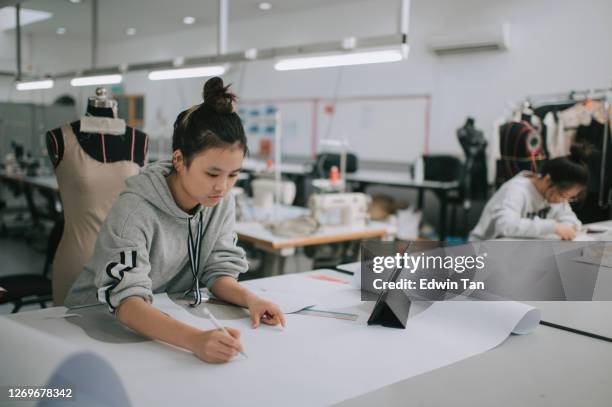 asiatische chinesische weibliche mode-college-studentin schreibt messung und zeichnung nähmuster tun kleidung projekt an college-workshop - gestalterischer beruf stock-fotos und bilder