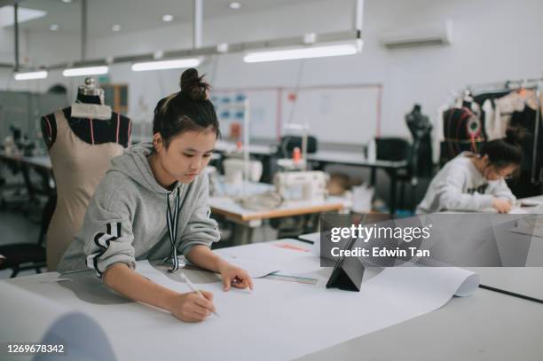 asian chinese female fashion college student writing down measurement and drawing sewing pattern doing clothing project at college workshop - fashion stock pictures, royalty-free photos & images