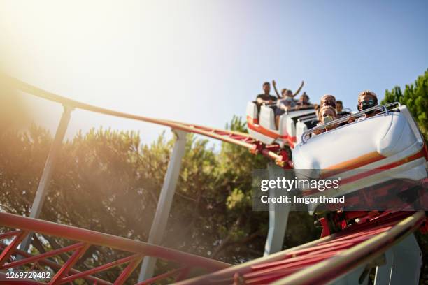 enfants s’amusant dans les montagnes russes de parc d’attractions pendant la pandémie de covid-19 - parc dattractions photos et images de collection