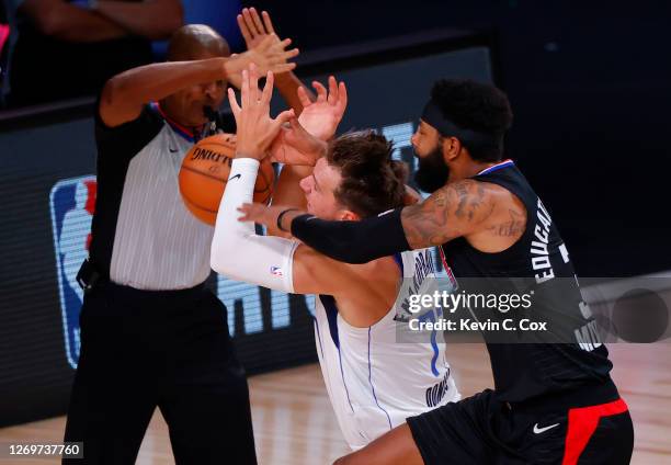 Marcus Morris Sr. #31 of the LA Clippers fouls Luka Doncic of the Dallas Mavericks during the first quarter in Game Six of the Western Conference...