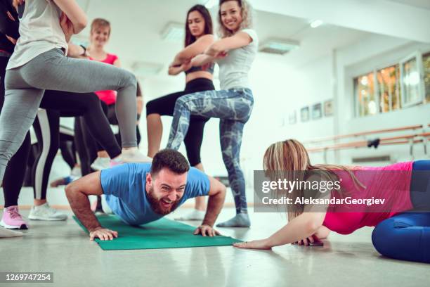 female athletes forcing male to exert himself in gym - stamping feet stock pictures, royalty-free photos & images