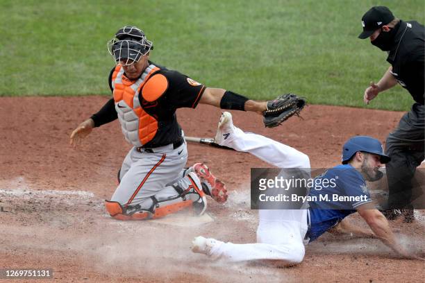 Pedro Severino of the Baltimore Orioles attempts to tag Randal Grichuk of the Toronto Blue Jays on a ball hit by Teoscar Hernandez of the Toronto...