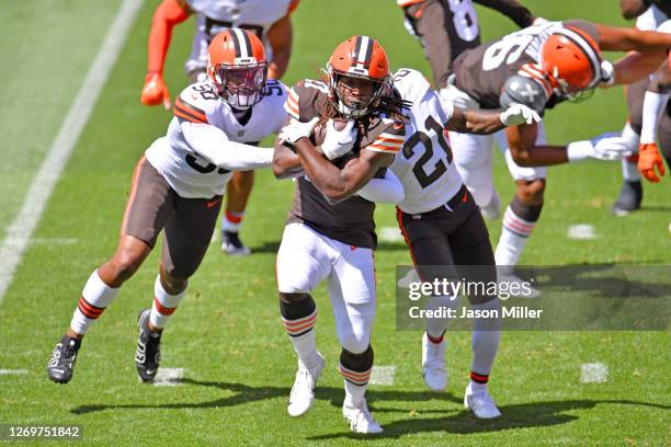 Linebacker Jacob Phillips and cornerback Denzel Ward try to stop running back Kareem Hunt of the Cleveland Browns during training camp at FirstEnergy...