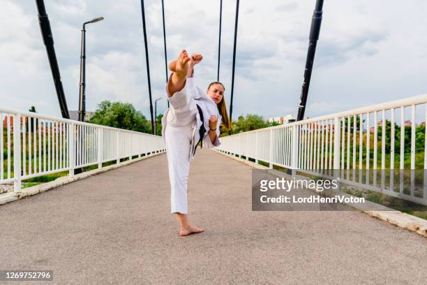 junge frau macht karate kick - women's judo stock-fotos und bilder