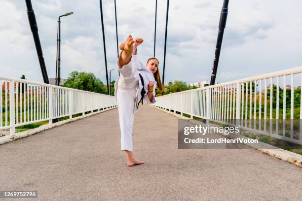 mujer joven hace patada de karate - women's judo fotografías e imágenes de stock