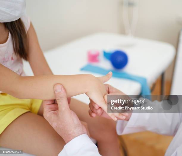 wrist massage. a male massage therapist puts pressure on a sensitive point on a kid's hand. - shiatsu stock pictures, royalty-free photos & images