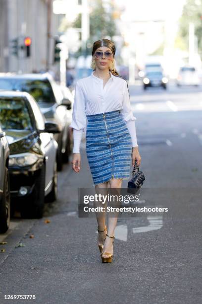 Hair stylist Svenja Simmons wearing sunglasses by Porsche, a white blouse by Steffen Schraut, a blue d´skirt by Balmain, a svcarf by Balmain, a bag...