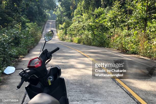 koh kood (ko kut) island in koh chang national park - motorcycle in the rural road along with tropical rain forest. - national lefties bildbanksfoton och bilder