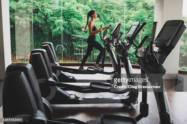 woman training on stepper or treadmill in fitness club of gym. side view. power and endurance functional cardio training. woman health. - peloton tread stock pictures, royalty-free photos & images