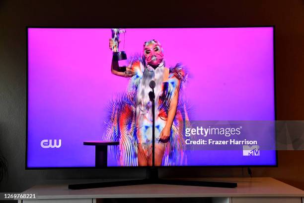 In this photo illustration, Lady Gaga accepts the Best Collaboration award for "Rain on Me" with Ariana Grande, viewed on a television screen, during...