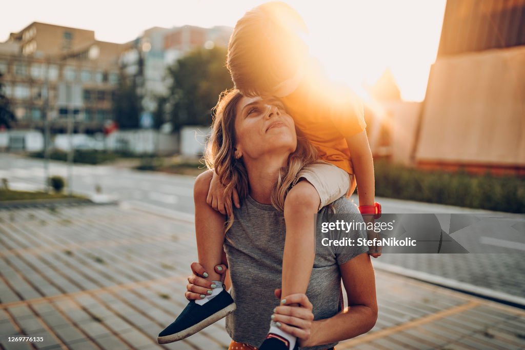 Mother and son playing in public park, driving scateboard