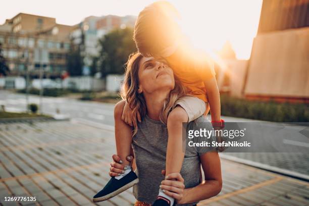 mother and son playing in public park, driving scateboard - city life stock pictures, royalty-free photos & images