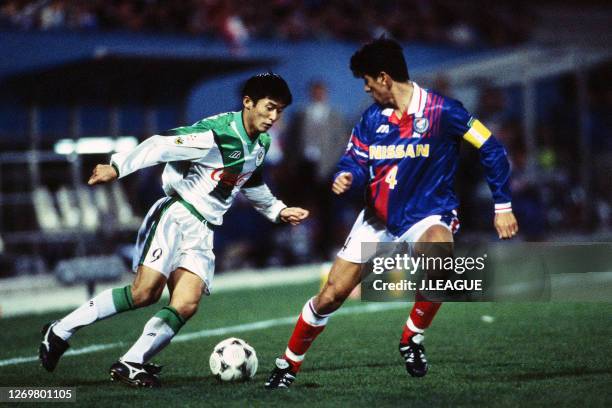 Nobuhiro Takeda of Verdy Kawasaki takes on Masami Ihara of Yokohama Marinos during the J.League Suntory Series match between Yokohama Marinos and...