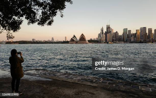 Woman fishes beside the harbour at sunset in the suburb of Kirribilli on August 29, 2020 in Sydney, Australia. Warm winter weather is being enjoyed...