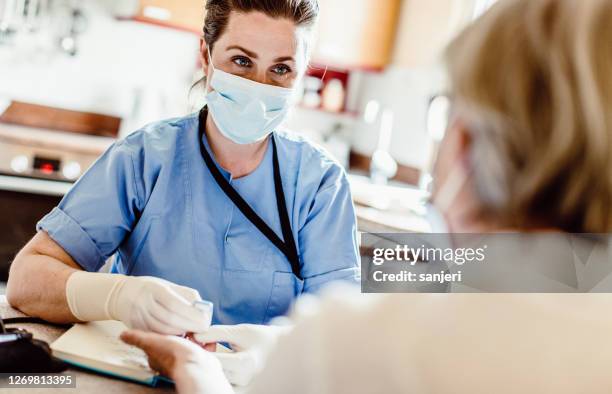 nurse visiting a senior patient at home - covid visit stock pictures, royalty-free photos & images