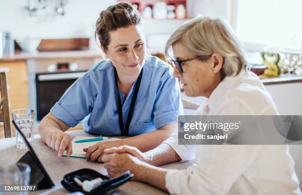 nurse visiting a senior patient at home - patient education stock pictures, royalty-free photos & images