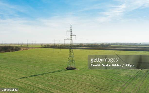 high voltage post on the agricultural field, hernd, hungary - alto voltaje fotografías e imágenes de stock
