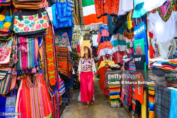 woman walking in a colorful market, guanajuato city, mexico - souvenirs stock-fotos und bilder