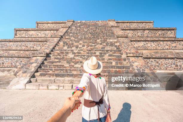 woman holding hand walking towards teotihuacan pyramid, mexico - human pyramid ストックフォトと画像