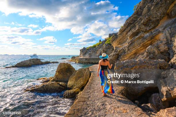 woman walking on a coastal pathway, isla mujeres, mexico - cultura caraibica foto e immagini stock