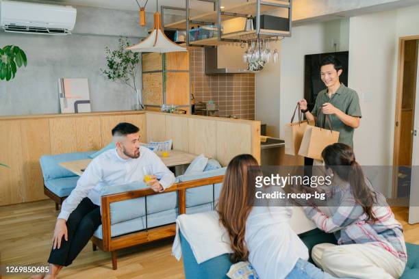 young friends getting ready for takeaway food for lunch in living room at home - friends social distancing stock pictures, royalty-free photos & images