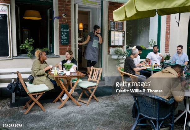 busy restaurant facade with people sitting and eating - ristorante foto e immagini stock