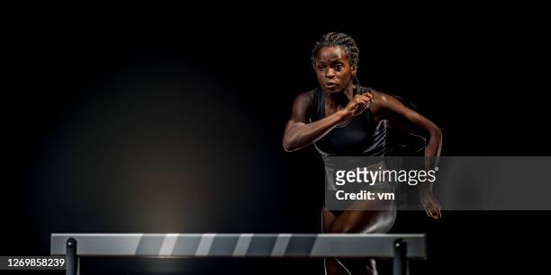 atleta africana a punto de saltar sobre un obstáculo - hurdling track event fotografías e imágenes de stock