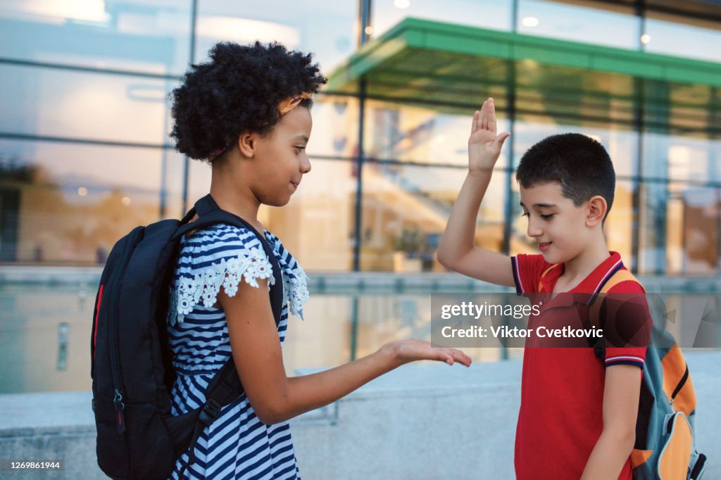 Dos Niños En Un Patio De La Escuela Saludando Entre Sí Dando Alto Cinco  Foto de stock - Getty Images