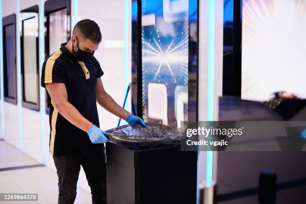 empleado masculino reemplazando bolsa de basura - bolsa de la basura fotografías e imágenes de stock