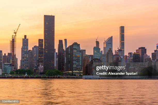 sunset in new york city, usa - east river stock-fotos und bilder