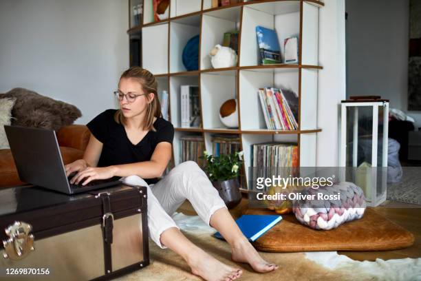 young woman sitting on the floor at home using laptop - woman flat chest 個照片及圖片檔