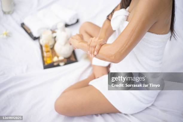 young women using massage oil with aromatherapy oil in the spa - huile de massage photos et images de collection