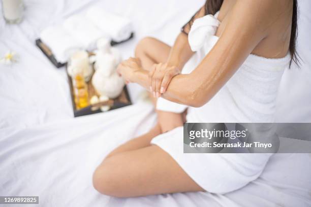 young women using massage oil with aromatherapy oil in the spa - aromatherapy oil - fotografias e filmes do acervo