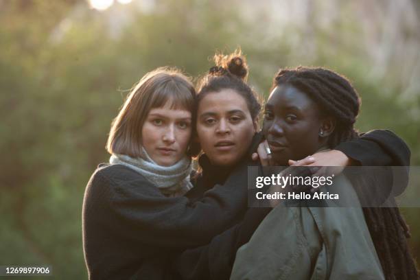 three beautiful young women embracing celebrating friendship - native african ethnicity stock pictures, royalty-free photos & images