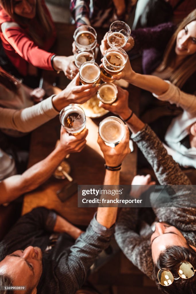 Vrouwen die binnen in een pub met de bieren spreken