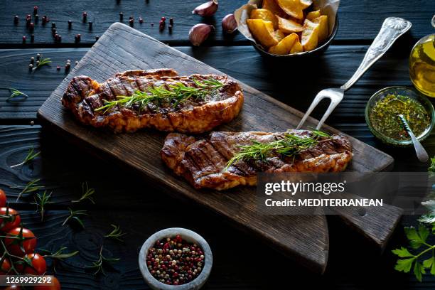 two grilled strip steaks new york steak on cutting board - lombo de vaca imagens e fotografias de stock