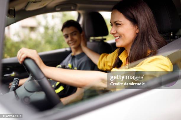 glad mamma och hennes tonårige son kör i bilen tillsammans - conversation car bildbanksfoton och bilder