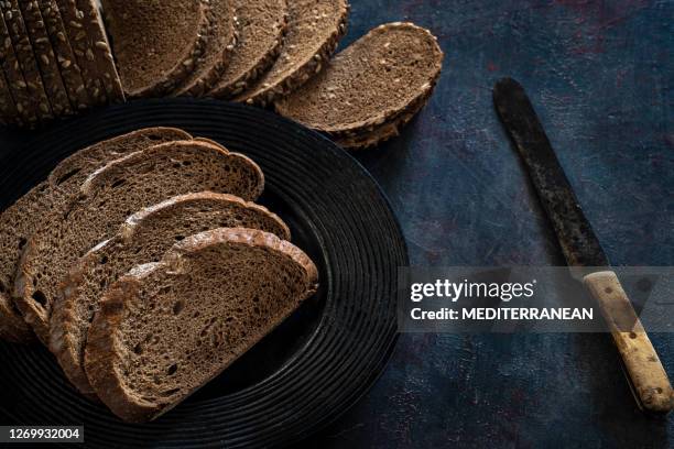 vollkornbrotscheiben in einer reihe auf dunkelgrauem rustikalen hintergrund - brotlaib stock-fotos und bilder