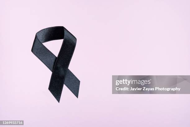 black ribbon on pink background - melanoma awareness stock pictures, royalty-free photos & images