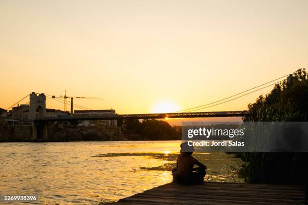 boy watching the sunset - ebro river stock-fotos und bilder