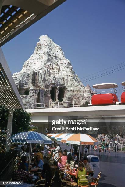 View of park goers taking a break at one of the outdoor food courts at Disneyland, Anaheim, California, October 4, 1973. Also visible is the...