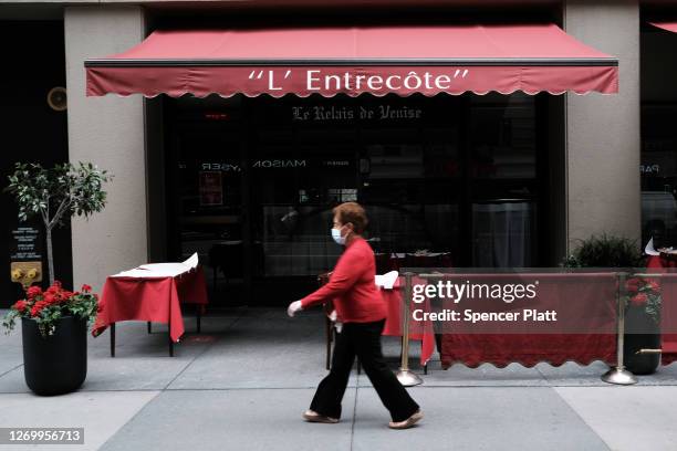 Woman walks by a restaurant in Manhattan on August 31, 2020 in New York City. While New York City restaurants are currently permitted to serve...