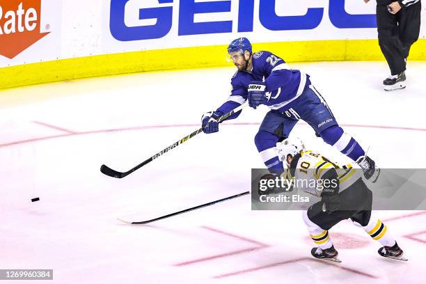 Brayden Point of the Tampa Bay Lightning is defended by Anders Bjork of the Boston Bruins in Game Five of the Eastern Conference Second Round during...