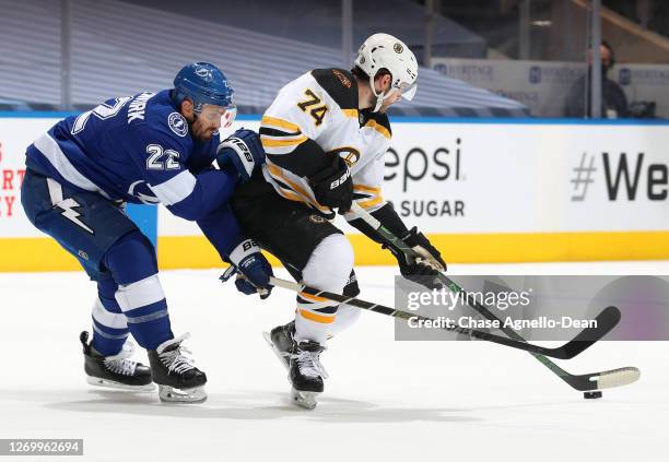 Jake DeBrusk of the Boston Bruins plays the puck from Kevin Shattenkirk of the Tampa Bay Lightning in the first period of Game Five of the Eastern...