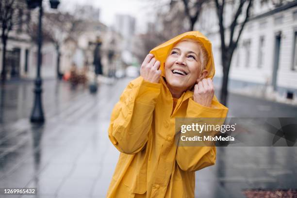 happy lady enjoying in spring weather - raincoat stock pictures, royalty-free photos & images