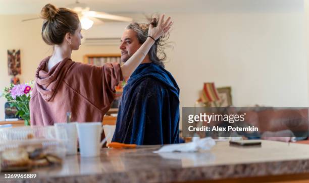 do it yourself - home haircut. late teenage girl, a daughter, gives a haircut to her father, mature 50-years-old man with long hair. - 18 19 years stock pictures, royalty-free photos & images