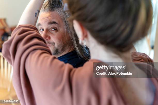 do it yourself - home haircut. late teenage girl, a daughter, gives a haircut to her father, mature 50-years-old man with long hair. - 18 19 years stock pictures, royalty-free photos & images