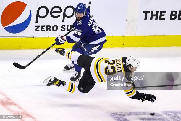 Charlie McAvoy of the Boston Bruins gets tripped up against Nikita Kucherov of the Tampa Bay Lightning during the second period in Game Five of the...